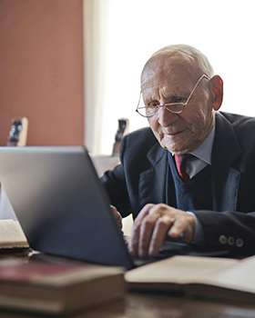 älterer Herr mit Laptop