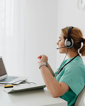 Pflegerin vor Laptop