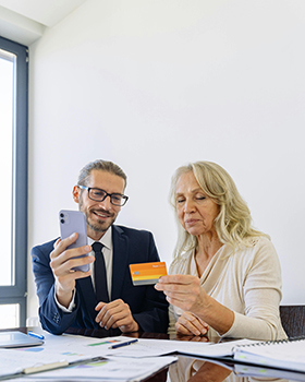 Ältere Dame bekommt von jüngerem Herrn nützliche Dinge auf dem Smartphone gezeigt